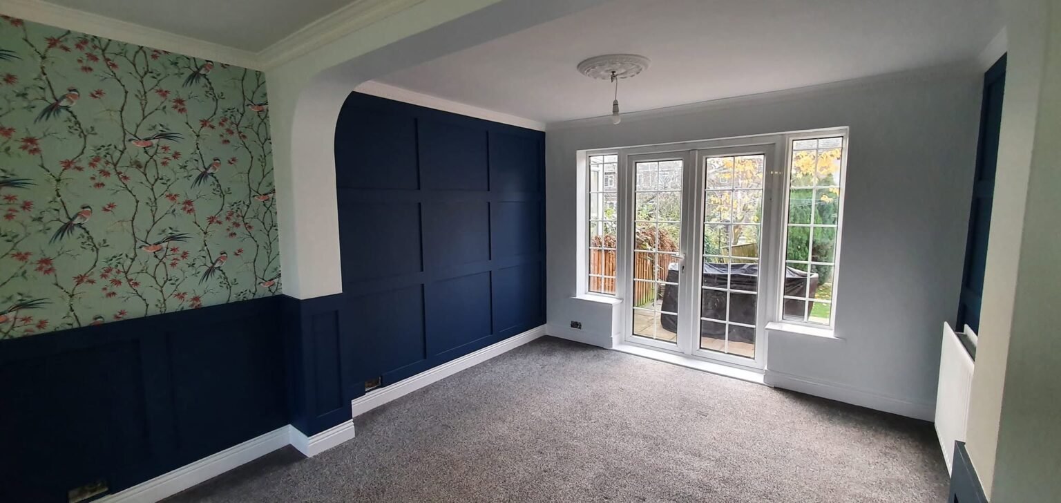 Navy panelled feature wall with chinoiserie wallpaper, decorated by North & Sons